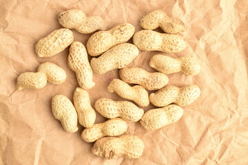 Unpeeled organic peanuts, close-up, on a jute cloth.