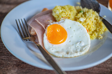 Close up Breakfast on the wooden table.fired egg ham and fired rice the easy breakfast in the morning.