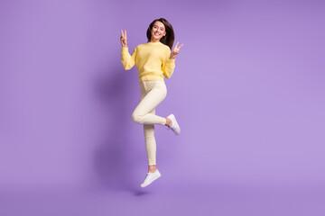 Fototapeta na wymiar Full length photo portrait of girl jumping up showing two v-signs isolated on vivid violet colored background
