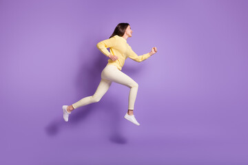 Fototapeta na wymiar Full length side angle photo portrait of girl running jumping up isolated on vivid violet colored background