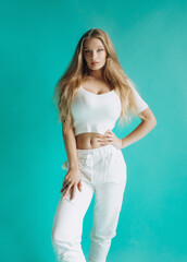 Amazing blonde in a sports suit posing in the studio. Homogeneous background.