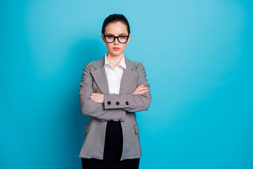 Portrait of attractive classy content serious lady coach folded arms isolated over vibrant blue...