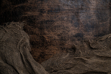 Dark old brown oak or birch or ash wood background and textured burlap.