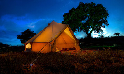 Bell tent at night against a blue hour sky