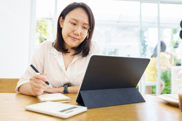 Asian woman aged 30-35 years using tablet, watching lesson online course communicate by conference video call from home, e-learning education concept