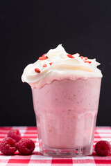 Raspberry smoothie with whipped cream and goji berries