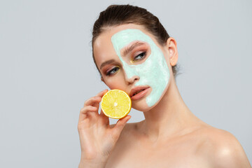 Portrait of beautiful woman with blue cream mask on her face.