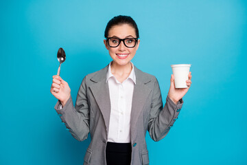 Portrait of attractive hungry cheerful funny lady eating tasty yummy lunch milky yogurt isolated on bright blue color background