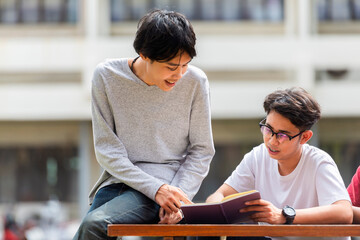 Asian Male Student studying brainstorming and talking at university.