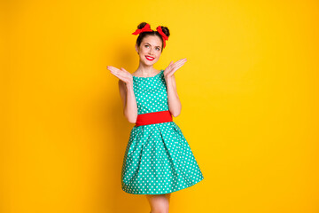 Portrait of lovely pretty cheerful girl wearing teal short dotted dress clapping palms isolated over bright yellow color background