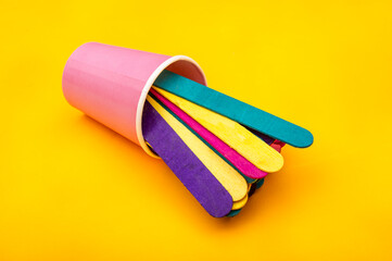 Colorful ice cream sticks coming out of cup - abstract background