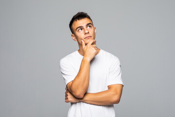 Young handsome man thinking isolated over gray background