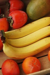 Juicy persimmons bananas and mango close up 