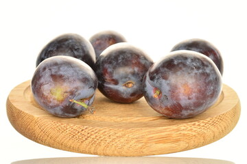 Ripe dark blue organic plums, close-up, on a white background.