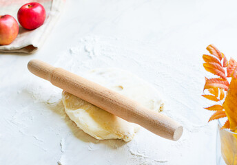Cooking pastry. rolling pin, dough and apples on the table with copy space for recipe