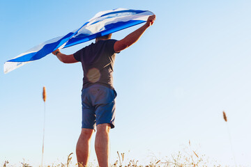 Man with a flag of Scotland standing in field