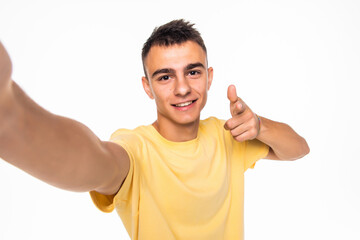 Happy man making selfie and pointed on you isolated on white background