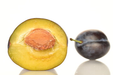 Ripe dark blue organic plums, close-up, on a white background.