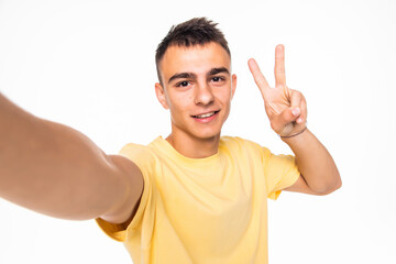 Happy man making selfie and showing peace isolated on white background