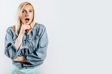 Beautiful young girl is surprised on gray isolated background