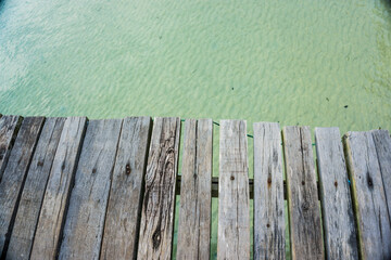 Empty brown wooden platform beside tropical sea beach