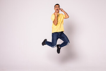 Happy excited young man jumping and celebrating success isolated on a white background