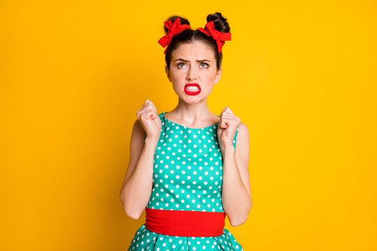 Photo of frustrated girl look up copyspace raise fists angry isolated over vibrant color background