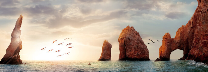 Rocky formations on a sunset background. Famous arches of Los Cabos. Mexico. Baja California Sur. Panoramic image. Banner format. - 390409460
