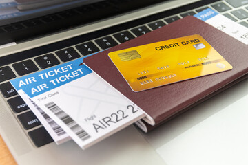 Credit card and passports near laptop computer on table. Online ticket booking concept