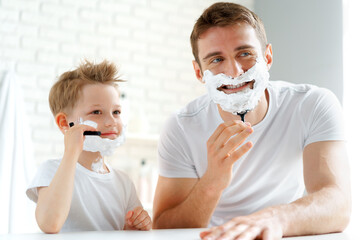 Father teaches his little son how to shave face