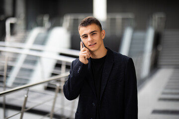 Young business man in office talking on the phone in modern office