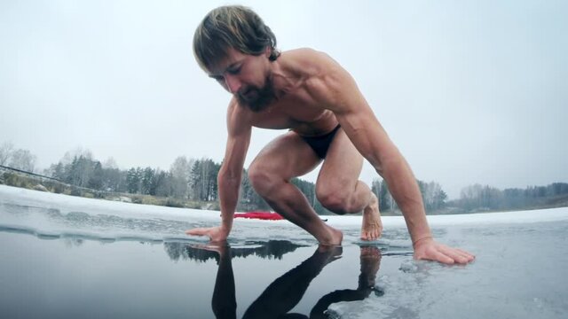 Winter swim. Young man swims in a winter lake