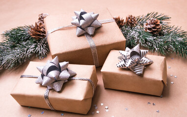 Naklejka na ściany i meble Congratulatory concept. Christmas gifts from craft paper on a beige background.