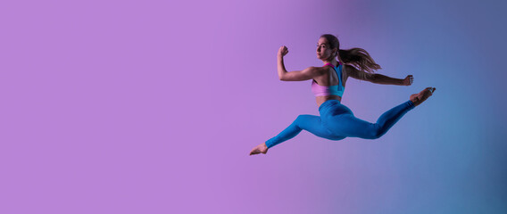 Flyer. Young sportive woman training isolated on gradient studio background in neon light. Athletic and graceful. Modern sport, action, motion, youth concept. Beautiful caucasian woman practicing.