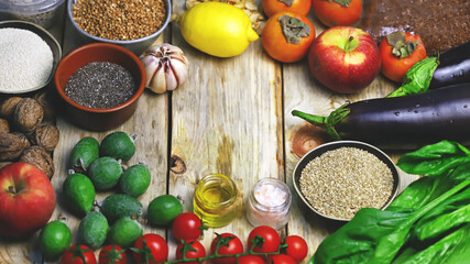 A set of useful products for a healthy diet. Vegetables, fruits, herbs, seeds. Cherry tomatoes, lemon, apples, persimmons, feijoa, quinoa, flaxseeds, buckwheat, walnuts, garlic, tea seeds, spinach.