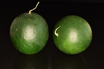 Ripe organic watermelons, close-up, on a black background.