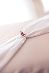 Pink silk pillowcase with pink beads in daylight. Love Story and Wedding mood. Can used like background.