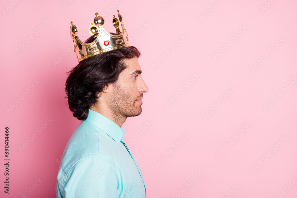 Wall mural Photo portrait profile of calm man in crown looking at blank space isolated on pastel pink colored background