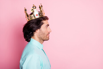 Photo portrait profile of calm man in crown looking at blank space isolated on pastel pink colored...