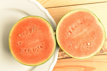 Sliced red organic watermelon, close-up, on a wooden table.