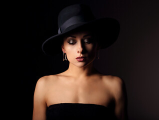 Fototapeta na wymiar Beautiful makeup woman with elegant healthy neck, nude back and shoulder on black background in fashion hat with empty copy space. Closeup front view portrait.