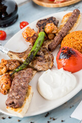 Mixed grill on wooden table. Lamb chops, Adana kebab, chicken shish, shish meatballs, steak.