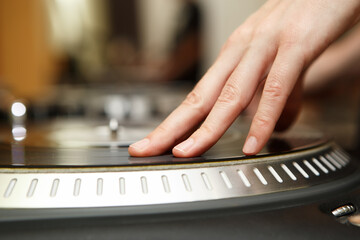 Dj girl plays music with retro turntable.Professional female disc jockey scratches vinyl record on...