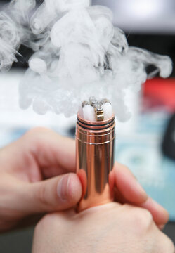 Vape cloud of electronic cigarette.Specialist services vaping device.New vaper cottong and titanium wire coils replaced in modern mech mod device for smoking e-liquid