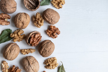 Walnut whole and peeled on a white wooden background with space for text. Article, poster.