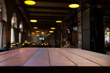 image of wooden table in front of abstract blurred background of resturant lights