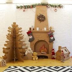 Cardboard Christmas home decoration with tree, gifts and fireplace.