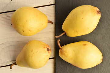 Ripe organic yellow-red pears, close-up, on a slate board.