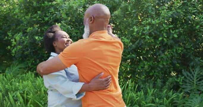African american senior couple dancing together in the garden