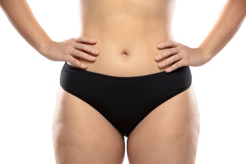 Fototapeta na wymiar Front view. Overweight woman with fat cellulite legs and buttocks, obesity female body in black underwear isolated on white background. Orange peel skin, liposuction, healthcare and beauty treatment.